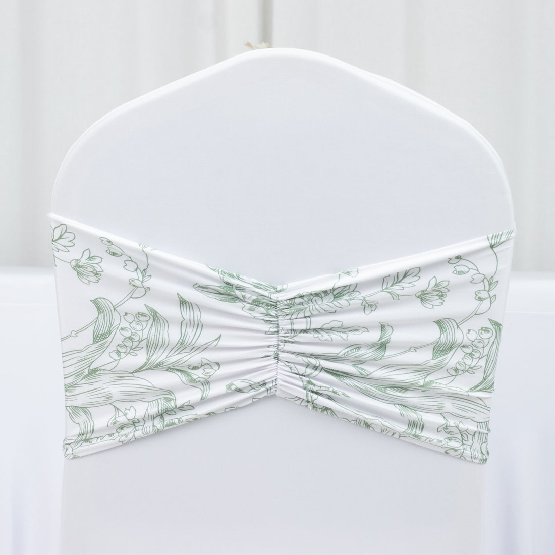 Floral patterned chair cover with ruched design on a plain backdrop