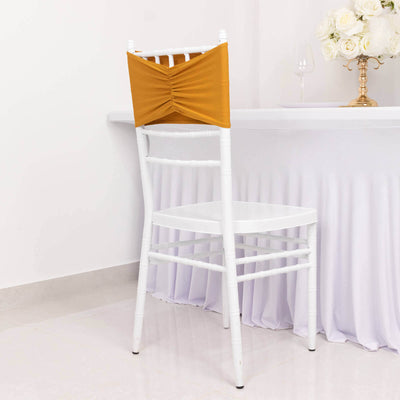 White chair with mustard yellow chair cover against a plain backdrop.
