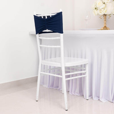 Navy chair cover draped on a white chiavari chair in an elegant setting.