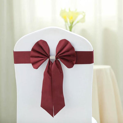 Burgundy chair sash with bow and rhinestone accent on a white chair