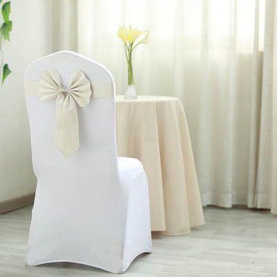 White chair cover with bow, styled for events, set in a bright indoor space.
