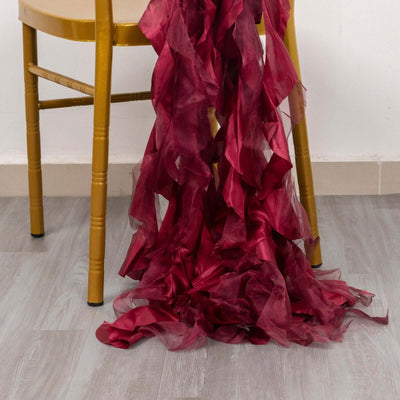 Crimson ruffled fabric draped on a golden chair leg.