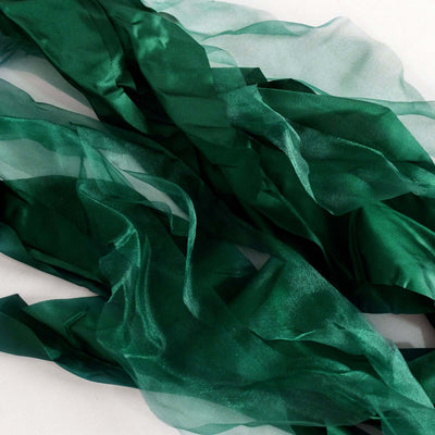 Green sheer fabric ribbons in flowing textures and layers.