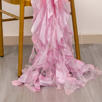 Pink ruffled fabric draped over a wooden chair leg.