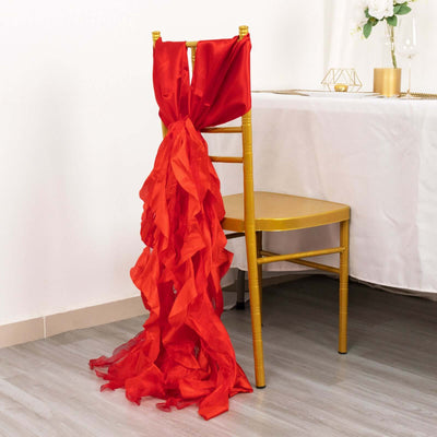 Red ruffled chair sash draped on a gold chair in an elegant setting.