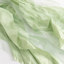 a close up of satin & taffeta chair sashes in green fabric#whtbkgd