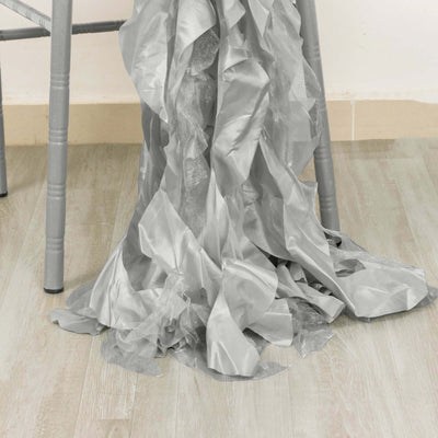 Crinkled silver fabric draped on a chair leg.