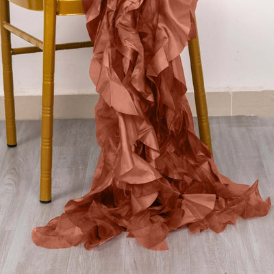 Crinkled rust-colored fabric draped elegantly from a chair leg.