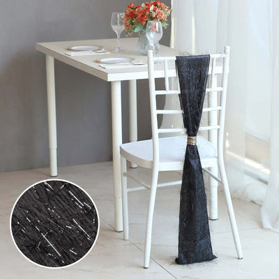Black chair sash draping elegantly on a white chair with a modern dining table.