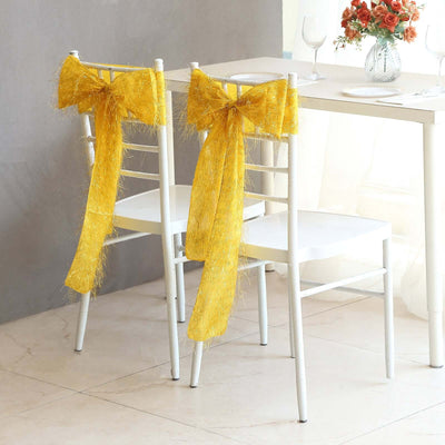 Yellow decorative bows on white chairs at a dining table.