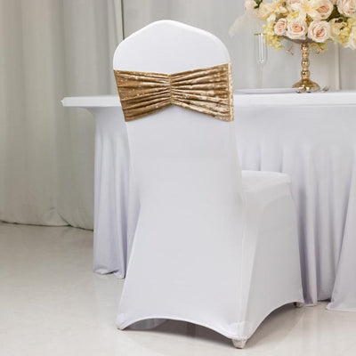 Elegant white chair cover with a gold bow, perfect for wedding or event decor.