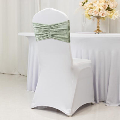 Elegant chair cover with a sage green velvet bow for event decor.