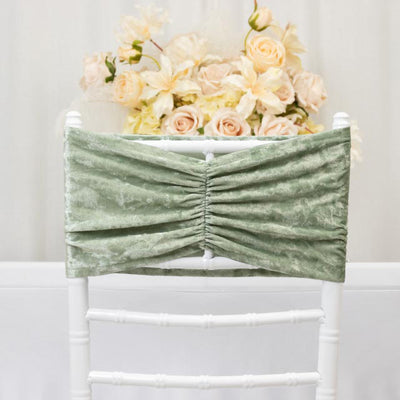 Green velvet chair cover with gathered design, styled against a floral backdrop.