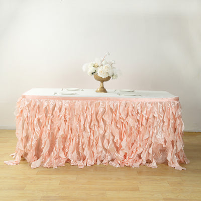 Pink ruffled table skirt with a white tablecloth and floral centerpiece.