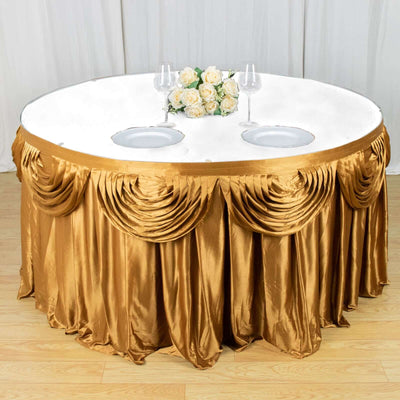 Gold pleated tablecloth draped over a round table with floral centerpiece.