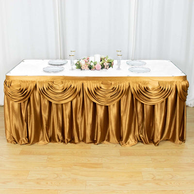 Gold satin table skirt with elegant draping and floral centerpiece.