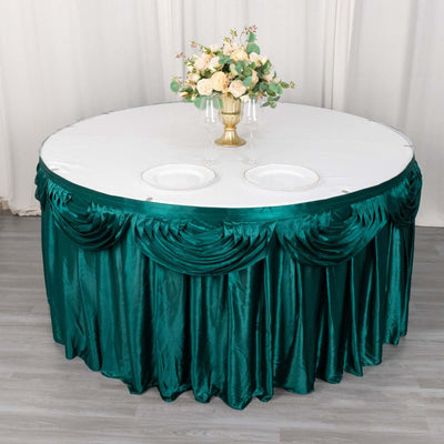 Round table with green satin skirt and floral centerpiece.