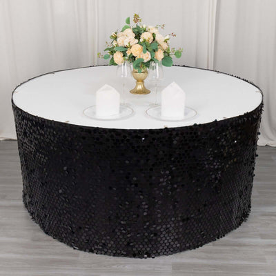 Black sequin table skirt with round table and floral centerpiece.