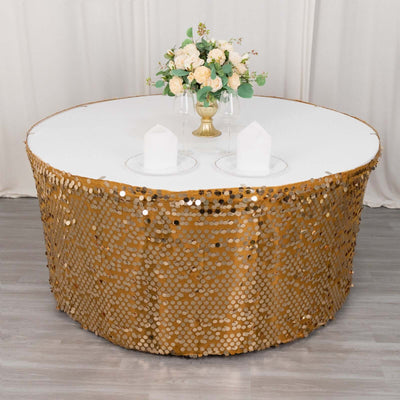 Round table with gold sequin skirt and white top, adorned with floral centerpiece.