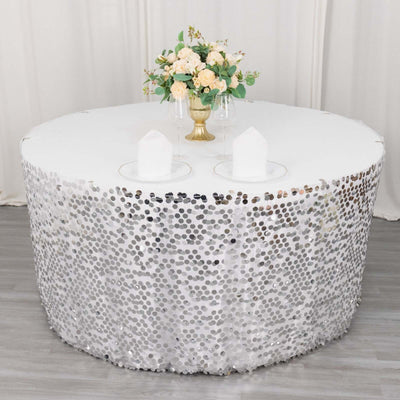 Round table with sequin tablecloth and floral centerpiece, elegantly styled for events.