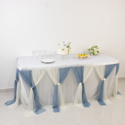 Table decorated with blue and white draped fabric for an event celebration.