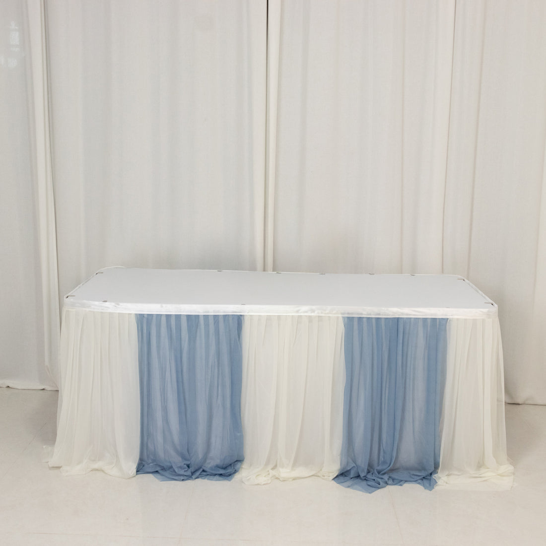 Table with blue and white draped fabric covering.