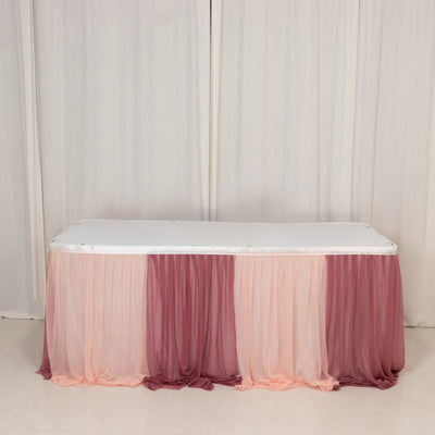 Table with soft pink and burgundy draped fabric skirt