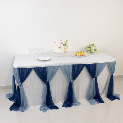Decorated table with blue and white drapes, cake, and dessert setup.