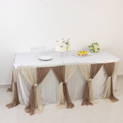 Elegant table setup with cake and desserts, adorned with soft fabric drapes.