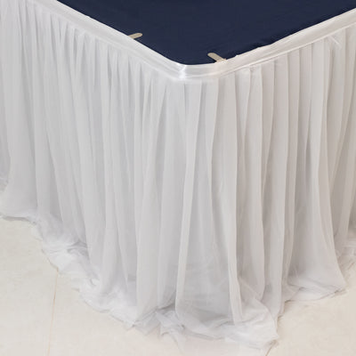 White table skirt draping elegantly over the edge of a navy tablecloth.