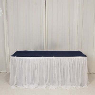 Navy tablecloth draped over a table with white sheer overlay