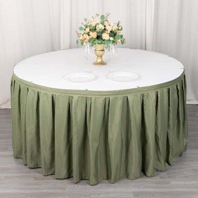 Round table with olive green skirt and floral centerpiece arrangement.