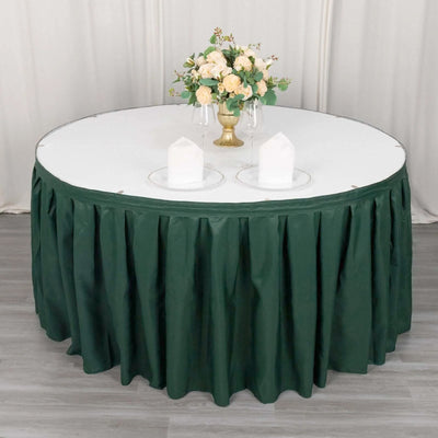 Round table with green skirt and floral centerpiece.