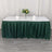 Green table skirt draped over a table set with plates and a vase of flowers.