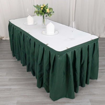 Green table skirt with white tablecloth and decorative centerpiece.