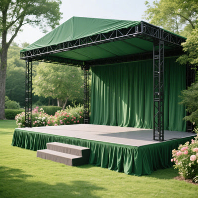 Outdoor event stage with green drapes and steps, surrounded by lush greenery.