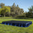 Outdoor event stage with blue skirt in a grassy park setting.