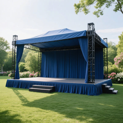 Outdoor performance stage with blue drapes and steps in a garden setting.