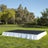 Outdoor event stage with black surface and white skirt in a grassy setting.