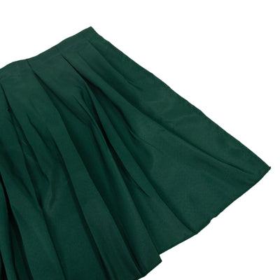 Green pleated skirt on a plain background