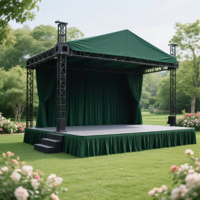 Outdoor stage with green drapes and a raised platform in a garden setting.