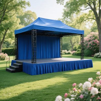 Blue outdoor event stage with canopy and steps in a garden setting.