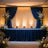 Elegant event stage with floral arrangements and draped curtains.