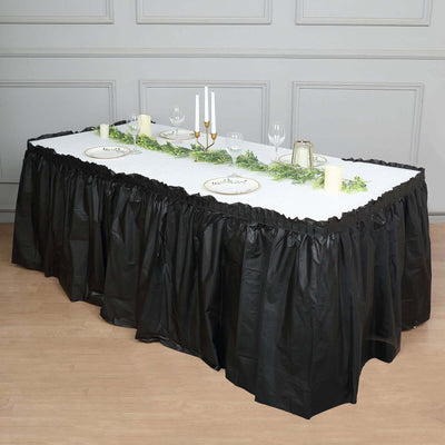 Black table skirt draping a banquet table set for an elegant dinner.