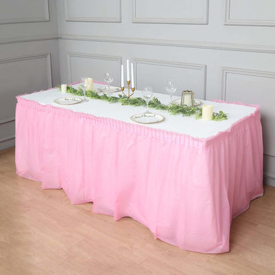 Pink table skirt with white tablecloth and decorative candles for events.