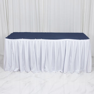 White banquet table with navy table cover and white pleated skirt on display