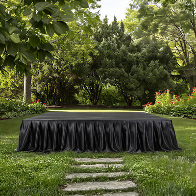 Elegant black draped table in lush green garden setting