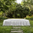 White draped table in lush garden with stone path and greenery