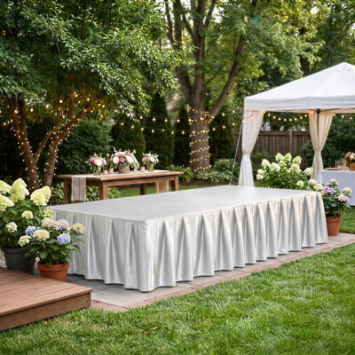 Elegant outdoor wedding reception setup with white tablecloths and string lights