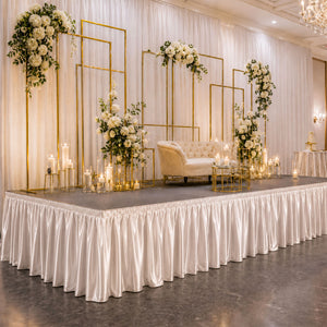 Elegant wedding stage with floral gold frames, candles, and cream sofa